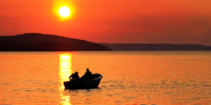 Fishing Boat on Lake at Sunset